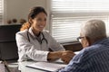 Happy physician shaking hands with grateful old man on meeting