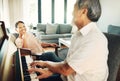 Happy, piano and senior man playing for music in living room with wife for bonding, entertainment or having fun Royalty Free Stock Photo