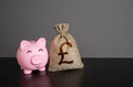 Happy piggy bank and british pound sterling money bag. Royalty Free Stock Photo