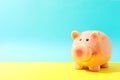 Happy piggy bank on yellow table against color background, space for text