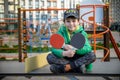 Happy ping pong player think about a game. young boy sitting after match on a tennis table outdoors