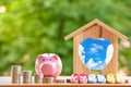 Happy Pink Piggy Bank and Home wooden in close-up and coins stack in the nature background, Saving ideas  and investment budget, B Royalty Free Stock Photo