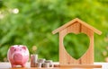 Happy Pink Piggy Bank and Home wooden in close-up and coins stack in the nature background, Saving ideas  and investment budget, B Royalty Free Stock Photo