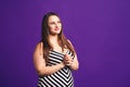 Happy pize size model in striped dress, fat woman on purple background