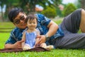 Happy and playful Asian Chinese man as loving father enjoying with sweet and beautiful baby girl daughter sitting together playing Royalty Free Stock Photo