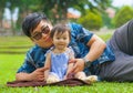 Happy playful Asian Japanese man as loving father enjoying sweet and beautiful baby girl daughter sitting together playing on Royalty Free Stock Photo