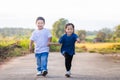 Happy playful children running outdoors in spring park. Asian kids playing in garden, boy and girl Royalty Free Stock Photo