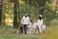 Happy playful family runing in park with pet. Young mom, dad having fun with three kids and big dog outdoors. Parents Royalty Free Stock Photo