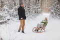 Happy playful mature family couple sledding in winter park, laughing and having fun together Royalty Free Stock Photo