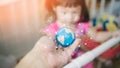 Happy playful toddler looking at globe ball on bed in bedroom at home Royalty Free Stock Photo