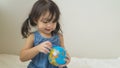 Happy playful toddler looking at globe ball on bed in bedroom at home Royalty Free Stock Photo