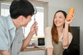 Happy and playful young Asian couple having a fun time while cooking in the kitchen together Royalty Free Stock Photo