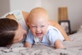 Happy, playing and a baby with mother on a bed for bonding, laughing and fun together. Smile, love and a family, child Royalty Free Stock Photo