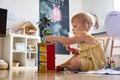 Happy girl toddler hitting wooden hammer on colored balls early development ecological toy Royalty Free Stock Photo