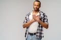 Happy pleased african-american man holding hands on chest to heart feeling love appreciation gratitude honesty Royalty Free Stock Photo