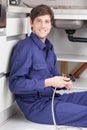 Happy plumber sitting on the floor Royalty Free Stock Photo