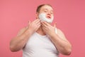 Happy plump man with shaving foam on his face and razor isolated on pink Royalty Free Stock Photo