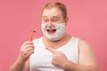 Happy plump man with shaving foam on his face and razor isolated on pink Royalty Free Stock Photo