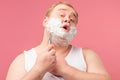 Happy plump man with shaving foam on his face and razor isolated on pink Royalty Free Stock Photo