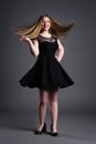 Happy plus size fashion model in black dress, fat woman on gray studio background, overweight female body Royalty Free Stock Photo