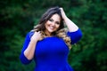 Happy plus size fashion model in blue dress outdoors, happiness beauty woman with professional makeup and hairstyle