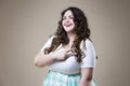 Happy plus size fashion model in casual clothes, fat woman on beige background, overweight female body Royalty Free Stock Photo