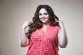 Happy plus size fashion model in casual clothes, fat woman on beige background, overweight female body Royalty Free Stock Photo