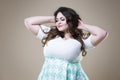 Happy plus size fashion model in casual clothes, fat woman on beige background, overweight female body Royalty Free Stock Photo