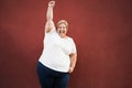 Happy plus size woman celebrating with winning gesture outdoors in the city - Focus on face Royalty Free Stock Photo