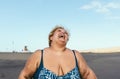 Happy plus size woman laughing on the beach - Curvy overweight model having fun during vacation in tropical destination