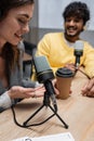 happy podcaster pointing at takeaway drink Royalty Free Stock Photo