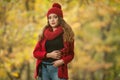 Happy Portrait fashion of a beautiful young Caucasian woman with a red cap and scarf and red jacket in autumn park Royalty Free Stock Photo