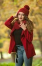 Happy Portrait fashion of a beautiful young Caucasian woman with a red cap and scarf and red jacket in autumn park Royalty Free Stock Photo