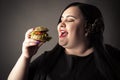 Happy portrait fat woman eating hamburger