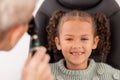 Happy portrait of girl, test eye vision by optician checking childs eyes in consultation room and smile at doctor