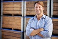 Happy, portrait and mature man by wooden crates for delivery, shipping or exporting business. Industry, storage and