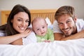 Happy portrait of mother, father and baby on bed for love, care and fun quality time together at home. Parents, cute