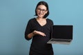 Happy Portrait smiling young asian woman holding laptop isolated on yellow background , Beautiful asian female holding notebook co Royalty Free Stock Photo