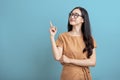 Happy Portrait smiling young asian woman isolated on blue background , Beautiful asian female pointing finger upward on blue Royalty Free Stock Photo