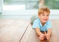 Happy, portrait and young child on floor in family home, wellness and playing games in lounge. Boy, face and smile in