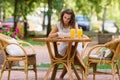 Happy, positive, beautiful, elegance girl sitting at cafe table outdoors.