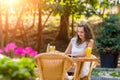 Happy, positive, beautiful, elegance girl sitting at cafe table outdoors.