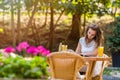 Happy, positive, beautiful, elegance girl sitting at cafe table outdoors.