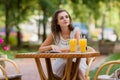 Happy, positive, beautiful, elegance girl sitting at cafe table outdoors.