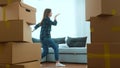 Happy positive couple of man and woman having fun dancing in room in new home with many boxes. Caucasian young wife and Royalty Free Stock Photo