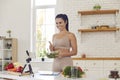 Cheerful fit vlogger filming culinary video, giving dieting tips and sharing healthy salad recipe