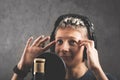 Happy positive guy with dreadlocks is recording a song in the studio. A young attractive singer in black studio headphones stands