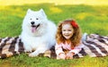 Happy positive little girl and dog having fun in sunny autumn