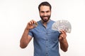 Happy positive man holding in hands and showing dollar bills and golden coin of crypto currency, transferring money into digital Royalty Free Stock Photo