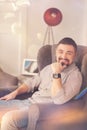 Happy positive man sitting in the armchair Royalty Free Stock Photo